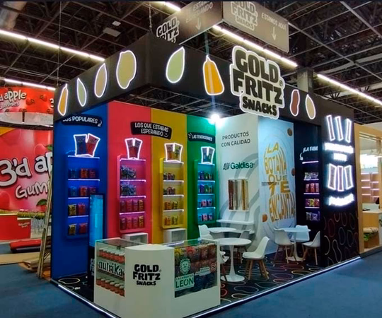 Gold Fritz Snacks展台设有色彩丰富的零食货架、品牌标识和明亮展览厅的座位区。